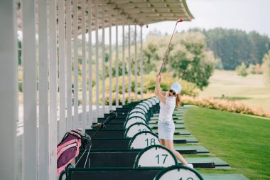 polo, şapka ve güneş gözlüğü kadınla golf club golf sahasında golf oynarken elinde