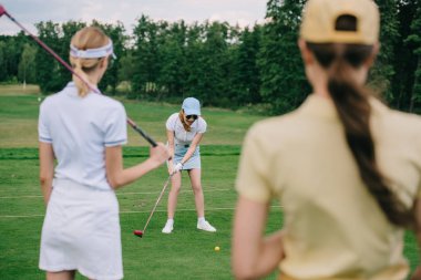 seçici odak kapaklar golf sahasında golf oynayan arkadaş bakarak golf ekipmanları ile kadınların