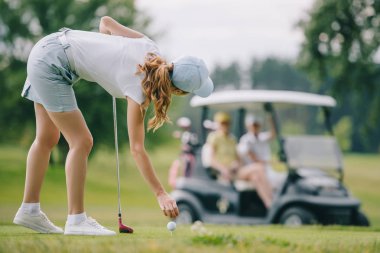 seçici odak oynarken golf golf sahasında golf arabası sürme arkadaşları ise kadının