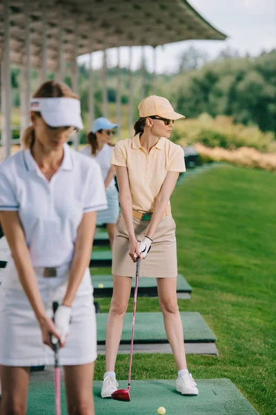 キャップとサングラス ゴルフ コースでゴルフをすることで女性の選択と集中 — ストック写真