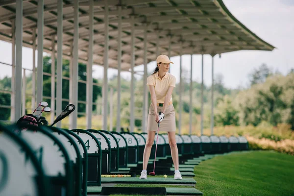 黄色のキャップとポロのゴルフコースでゴルフの女性 — ストック写真