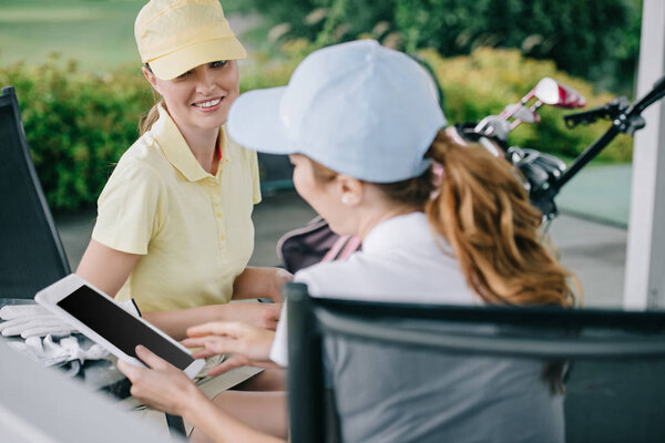 business partners with tablet discussing work after golf game at golf course