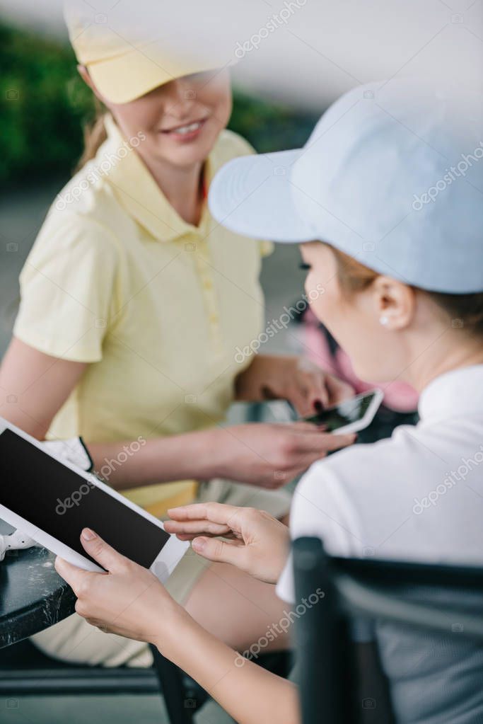 Business partners with tablet discussing work after golf game at golf course