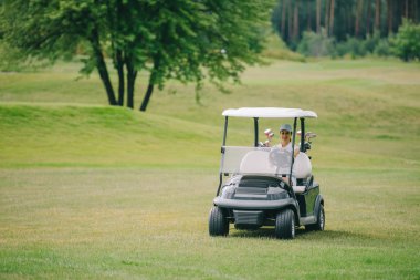 kadın kap Binicilik golf arabası golf sahasında yaz gününde