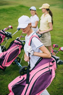 seçici odak kadınların kapaklar ile golf sahasında golf ekipmanları