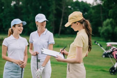 kadın iş ortakları ile not etmek golf sahası golf oyun sırasında proje tartışıyor