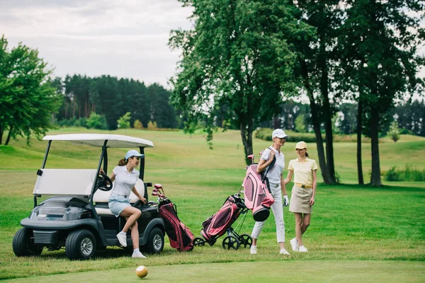 kadın golf oyuncuları kapaklar yaz gününde golf sahasında golf ekipmanları ile Grup
