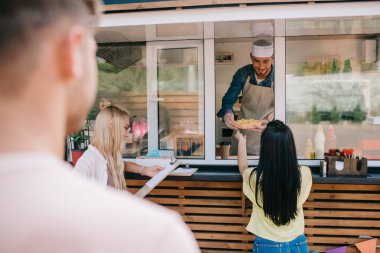 selective focus of young people buying fast food at food truck clipart