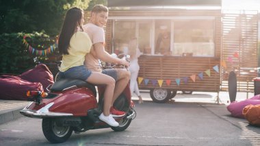 mutlu çift gıda kamyon sokakta yakınındaki motosiklet üzerinde oturan