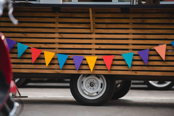 wheels and bottom part of food truck with colorful flags 