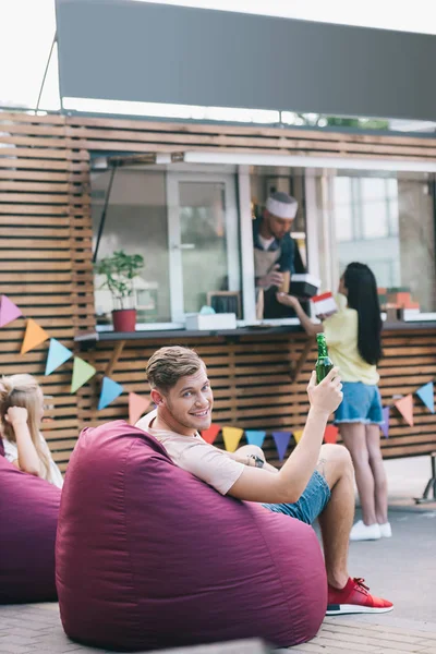 Smiling Man Holding Bottle Beer Food Truck Looking Camera — Free Stock Photo