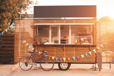 food truck with bicycle during sunset clipart