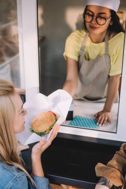 Şef müşteri gıda kamyonda burger veren yüksek açılı görünüş 