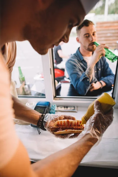 Szef Kuchni Przygotowuje Hod Dog Food Truck Klienta Picia Piwa — Darmowe zdjęcie stockowe
