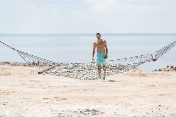 Selective Focus Hammock Shirtless Man Walking Beach Background — Free Stock Photo