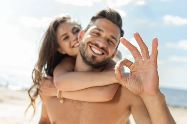 Selective Focus Man Showing Sign Piggybacking His Girlfriend — Stock Photo, Image