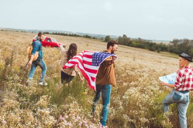 mutlu genç Amerikan gezginler çiçek alanı tarafından yürüyüş bayrak ile Grup