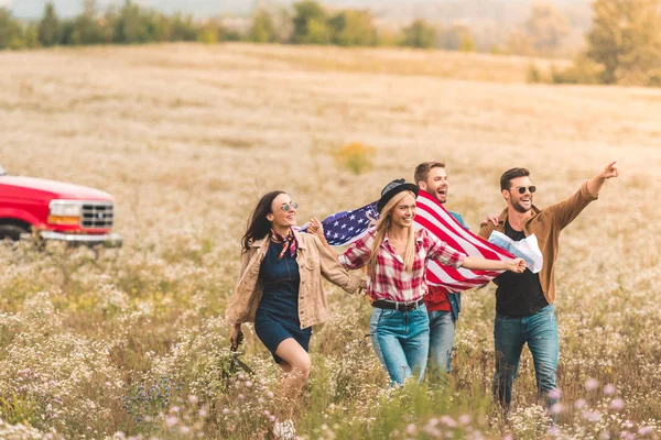 Grupo Jóvenes Viajeros Americanos Con Bandera Caminando Por Campo Flores —  Fotos de Stock