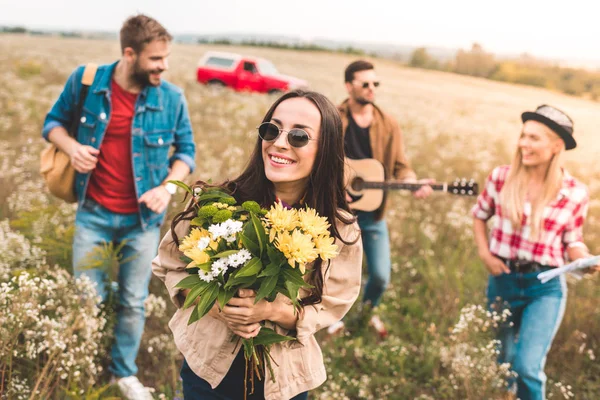 Grupo Jovens Caminhando Por Campo Com Guitarra Buquê Flores — Fotografia de Stock