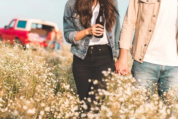 手を繋いでいると花畑を歩いてのカップルのショットをトリミング — ストック写真