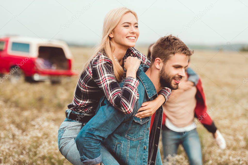 attractive young woman piggybacking on boyfriends back
