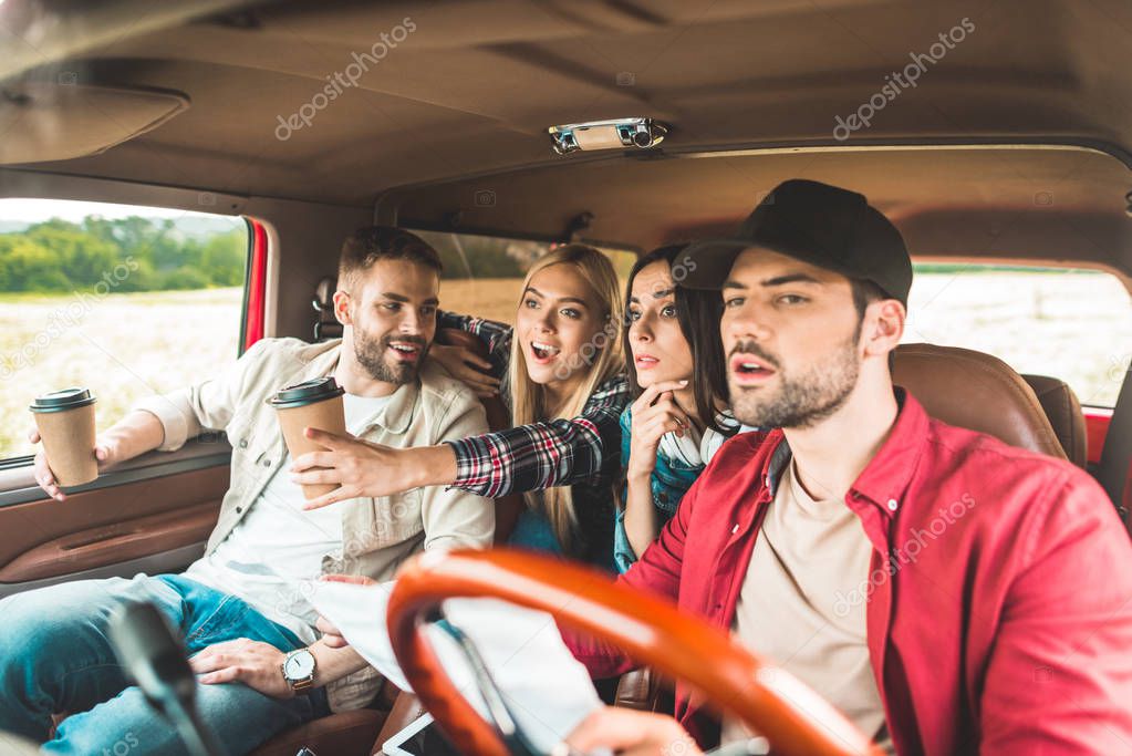 group of young people planning car journey and looking forward