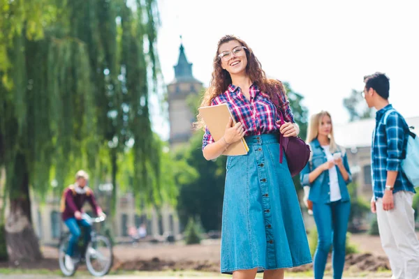 Selektivní Fokus Usměvavá Studentka Poznámkový Blok Multikulturní Spolužáky Ulici — Stock fotografie