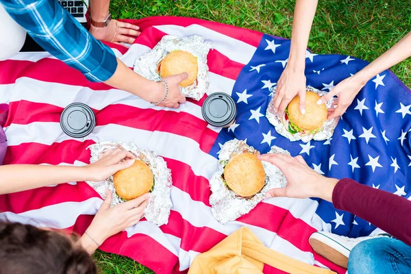 Teilansicht Von Freunden Mit Burgern Und Amerikanischer Flagge Auf Grünem — kostenloses Stockfoto