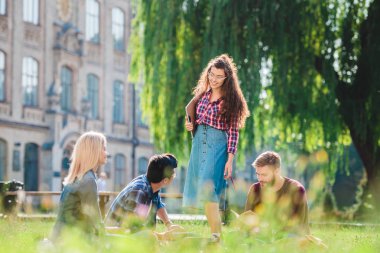Park arka plan üzerinde Üniversitesi ile dinlenme çok ırklı öğrenciler