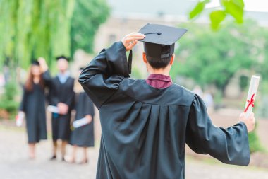 selective focus of group of graduates in summer park clipart