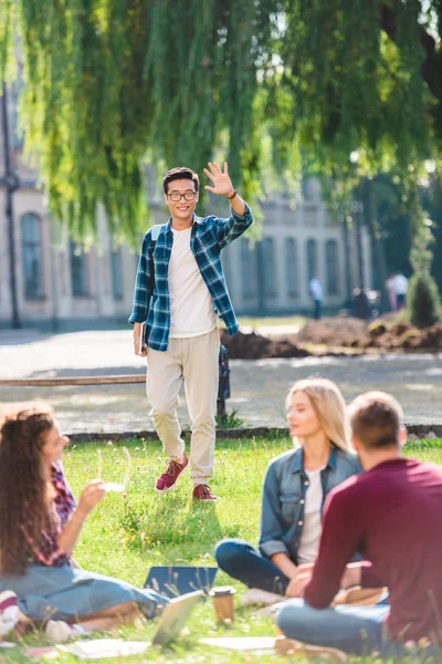 Multiraciale Studenten Rusten Park Met Universiteit Achtergrond — Gratis stockfoto