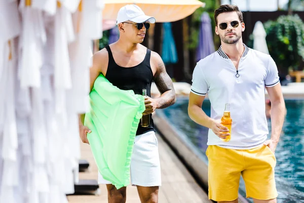 Männliche Freunde Spazieren Mit Aufblasbarer Matratze Und Bier Schwimmbadnähe — kostenloses Stockfoto
