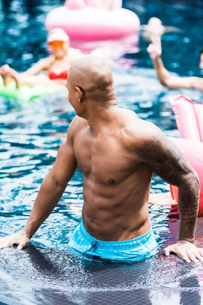 Young Tattooed Man Poolside Talking Friends Swimming Pool — Free Stock Photo