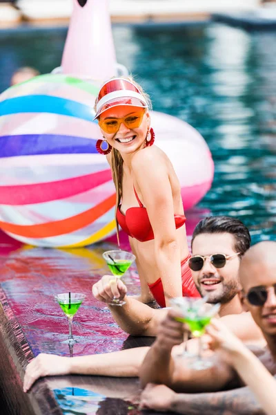 Mujer Sonriente Mirando Amigos Con Cócteles Cerca Piscina — Foto de Stock