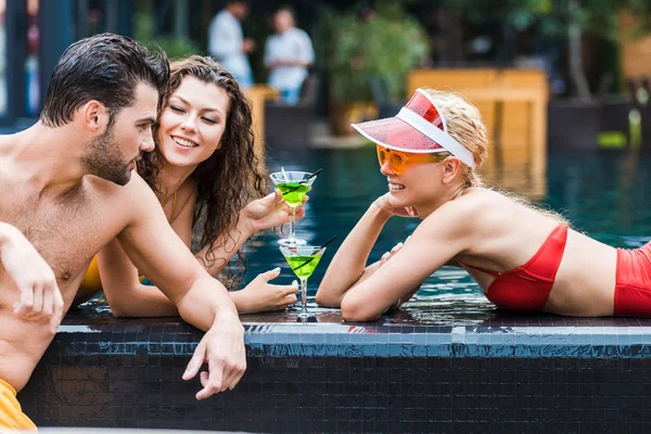 Young Man Talking Female Friends Cocktails Poolside — Stock Photo, Image