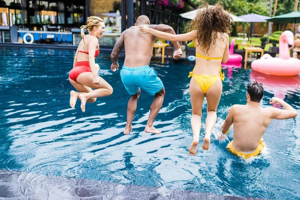 Rear View Male Female Friends Jumping Swimming Pool — Stock Photo, Image