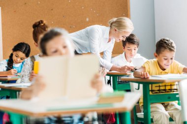 öğretmen çocuklara ders sırasında çalışma ile yardım gülümseyen