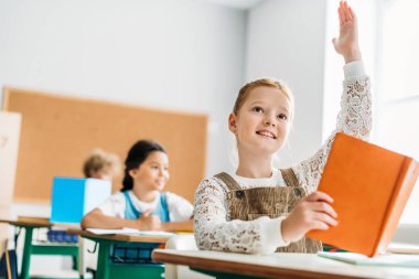 ders sırasında öğretmenler soru cevaplamak için el yükselterek kız öğrenci