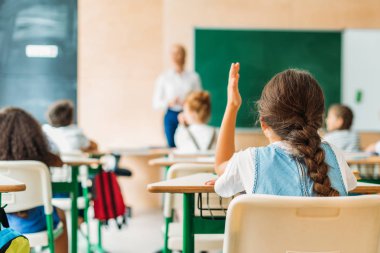 arkadan görünüşü ders sırasında öğretmenler soru cevaplamak için el yükselterek kız öğrenci