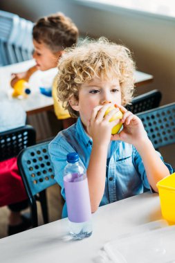 adorable curly schoolboy taking lunch together at  school cafeteria clipart