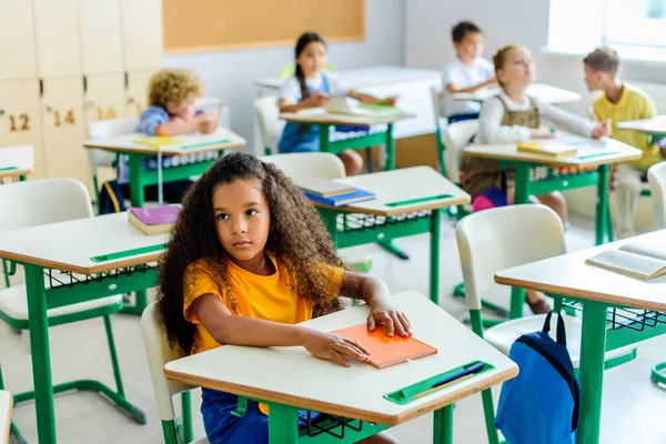 Piękny Znudzony Uczennica African American Siedząc Lekcji Kolegami Niewyraźne Tle — Zdjęcie stockowe