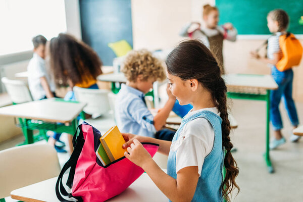 group of schoolchildren preparing for lesson at classroom