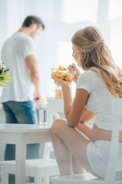 hamile kadının kocası sayaç mutfakta ayakta iken meyve salatası yemek seçici odak
