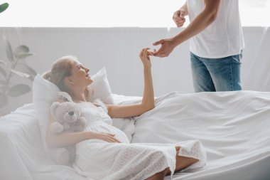ve evde elele kanepe üzerinde beyaz Geceliği içinde hamile karı koca