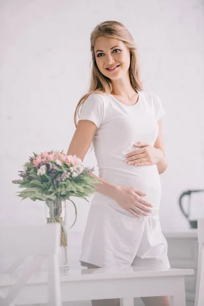 Mulher Grávida Feliz Mesa Com Buquê Flores Vaso Casa — Fotografia de Stock