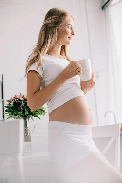 Donna Incinta Sorridente Con Una Tazza Guardando Lontano Casa — Foto Stock