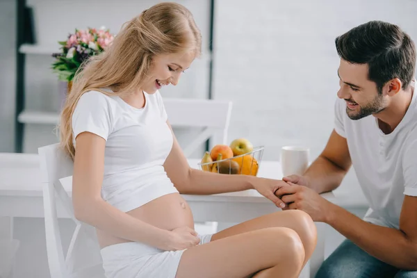 Side View Smiling Pregnant Woman Husband Holding Hands Table Home — Stock Photo, Image
