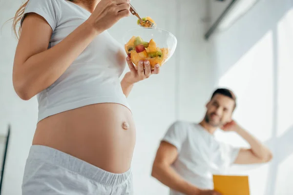 Partial View Pregnant Wife Fruits Salad Husband Book Kitchen Home — Stock Photo, Image