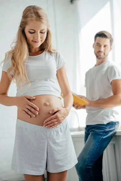 Man Book Hands Looking Pregnant Woman Home — Free Stock Photo