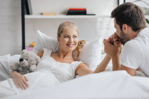 Man Pregnant Wife White Nightie Sofa Holding Hands Home — Free Stock Photo